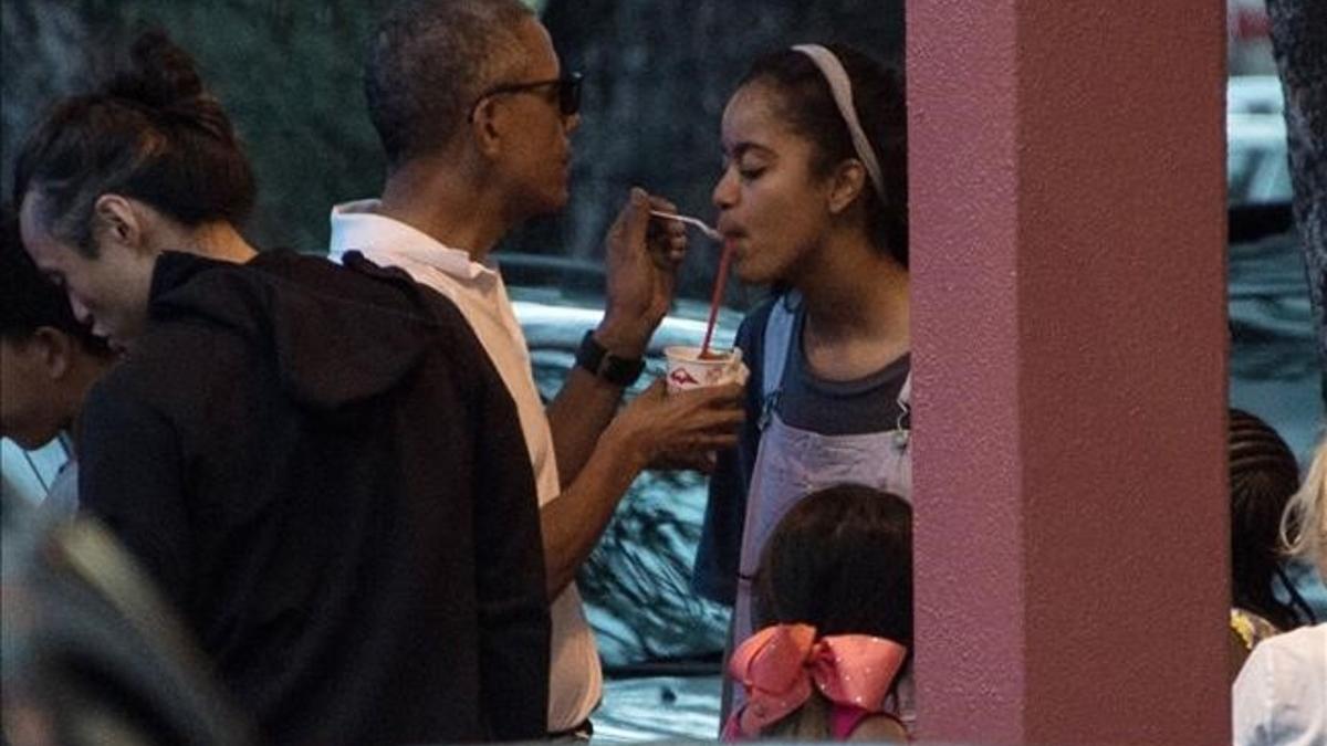 Obama da a su hija Malia un poco de su granizado, la pasada Nochebuena en Kailua (Hawai).