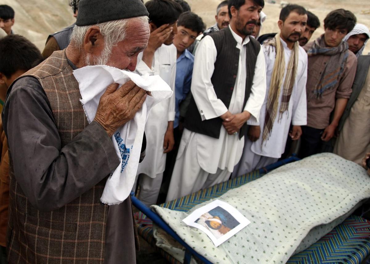 KAB01. Kabul (Afghanistan), 24/07/2016.- A man cries as people attend the funeral of the victims a day after a suicide bomb attack in Kabul, Afghanistan, 24 July 2016. According to reports at least 80 people were killed and more than 550 injured when a bomb exploded a day before in Kabul, as thousands of people from Hazara minority were protesting the proposed route of the Turkmenistan, Uzbekistan, Tajikistan, Afghanistan and Pakistan (TUTAP) power line, calling on the government to re-route the line through Bamiyan province which has a majority of Hazara population. (Afganistán, Atentado, Tadjikistan) EFE/EPA/JAWAD JALALI