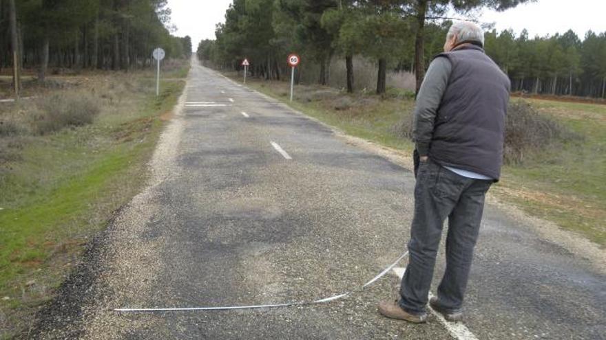 Un conductor midiendo ayer la plataforma de la carretera de Alcubilla de Nogales .