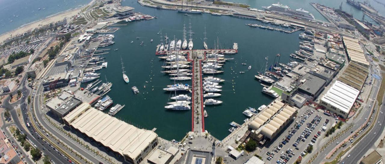 La Marina Real Juan Carlos I (Marina de València) con el pantalán de megayates en el centro, los tinglados modernistas a la izquierda, las bases deportivas y el canal presidido por el moderno edificio Veles e Vents.