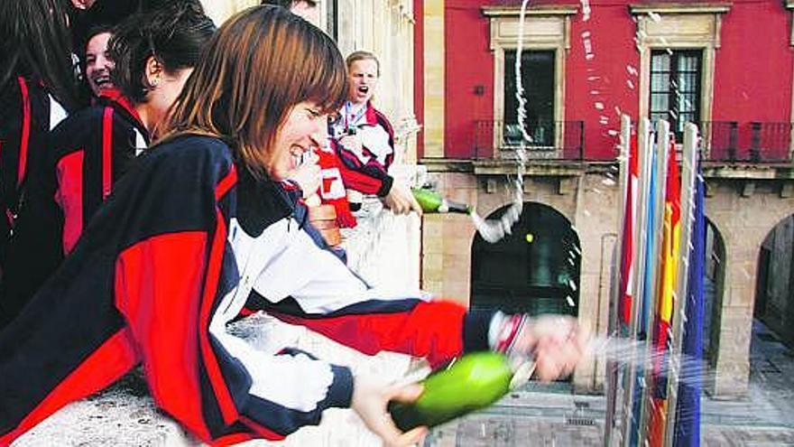 Arriba, las jugadoras del Biesca Gijón rocían con champán a los aficionados reunidos en la plaza Mayor; abajo, los componentes del club brindan con la alcaldesa, Paz Fernández Felgueroso, y el concejal de Deportes, José Ramón Tuero.
