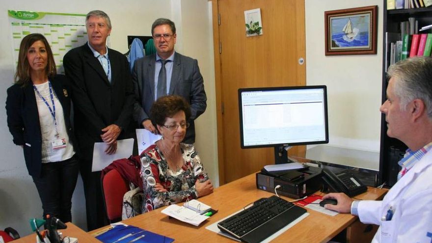 El doctor José Antonio Tarrazo, del centro de salud de Pola de Siero, expende la receta electrónica a Ángeles Suárez. Tras la paciente, Beatriz López, subdirectora de Atención Sanitaria y Salud Pública del área IV; Marco Margolles, director general de Planificación, Ordenación e Innovación Sanitaria, y Antonio Álvarez, director de Atención Sanitaria del área IV.