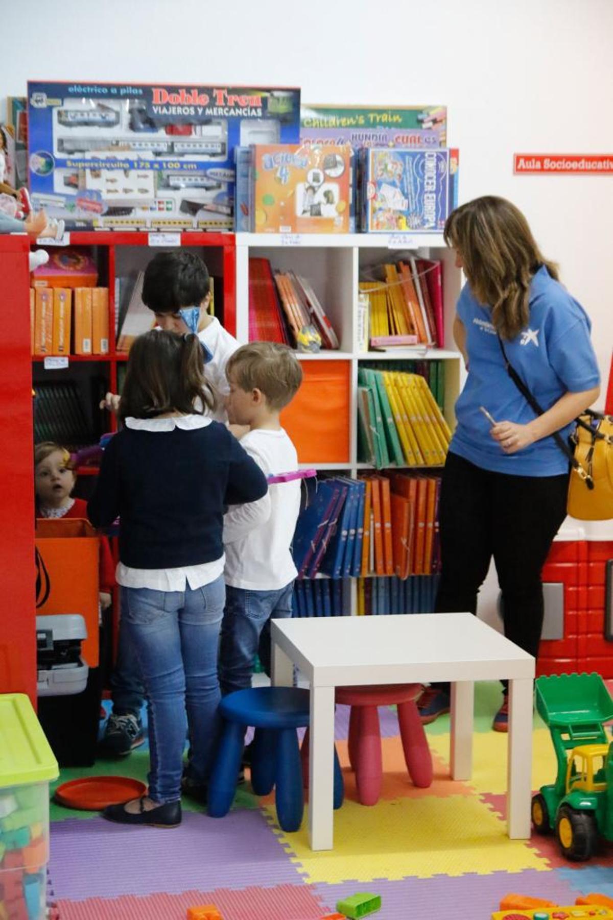 Un grupo de niños en riesgo de exclusión social son atendidos por una monitora.