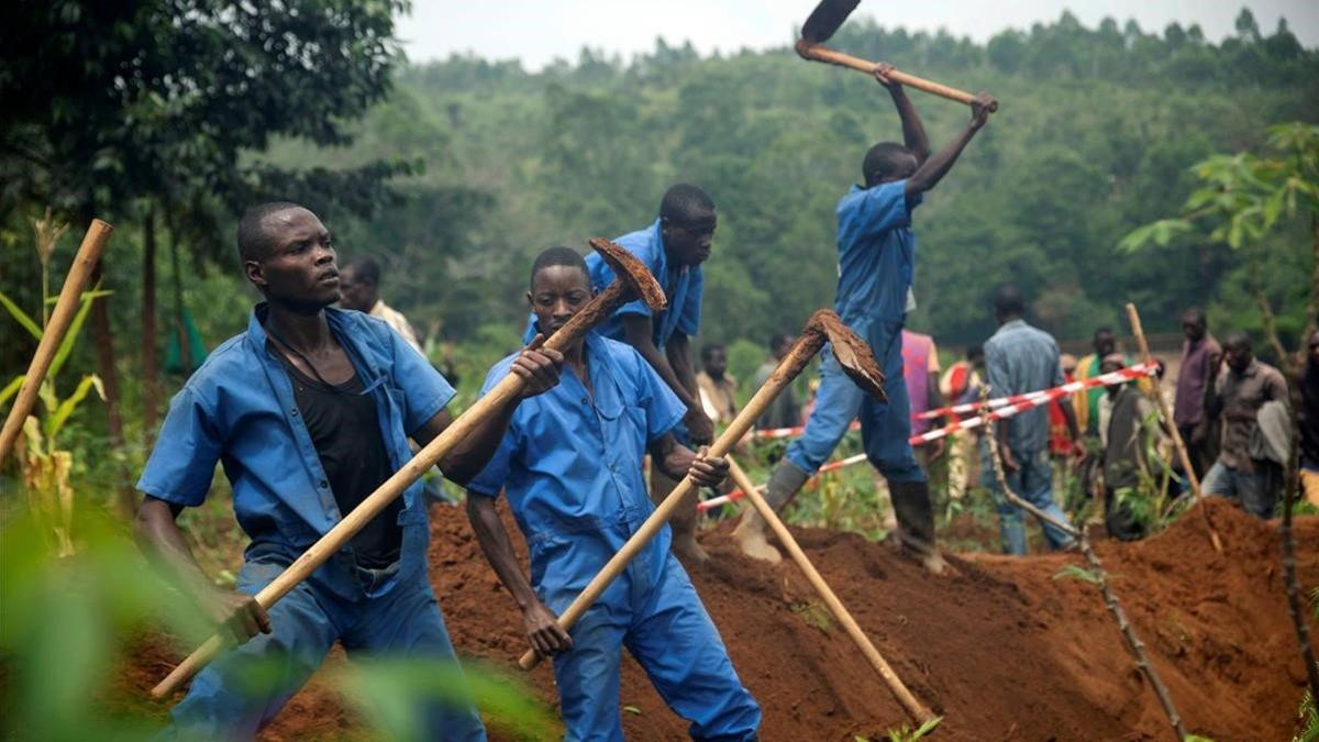 Trabajadores de la Comision de la Paz y la Reconciliacion de Burundi durante una de las excavaciones donde se han encontrado los cadaveres de miles de personas.