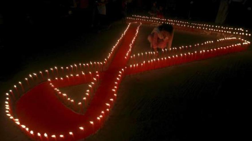 Una activista de una ONG enciende velas por el Día Mundial del Sida en Agartala, India.