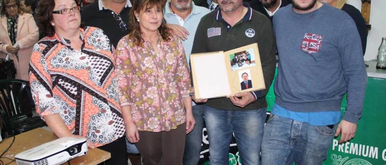 Miembros de la asociación posan con el álbum.