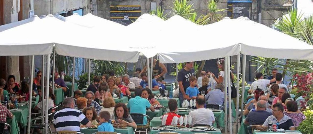 Clientes en una de las terrazas situadas en la plaza de O Berbés hace escasos días. // Marta G. Brea