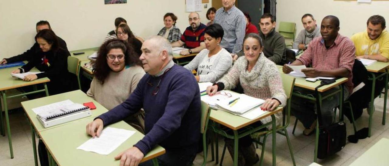 El docente Rafa Fernández, de pie, imparte Matemáticas en el aula mixta de preparación de pruebas libres en el Centro de Educación de Adultos.