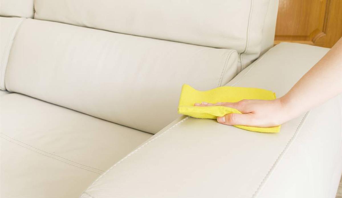 Quitar la suciedad del sofá con limpiador de tapicería, primer plano