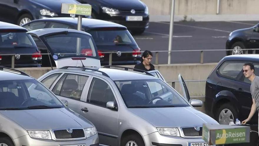 Dos turistas recogen su coche de alquiler en el aeropuerto