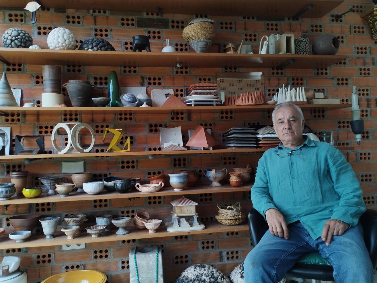 Benjamín Menéndez en su estudio con obra cerámica a su espalda.
