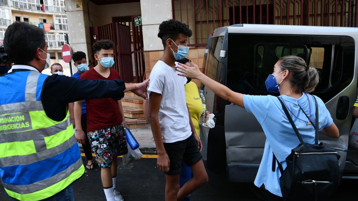 Trabajadores acompañan a tres menores marroquiíes ante los Juzgados de Ceuta.