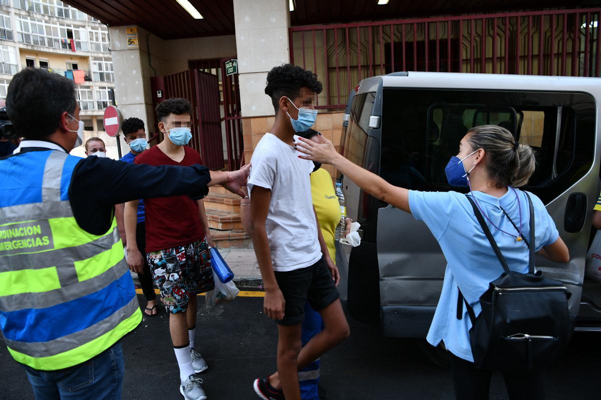 Trabajadores acompañan a tres menores marroquiíes ante los Juzgados de Ceuta.