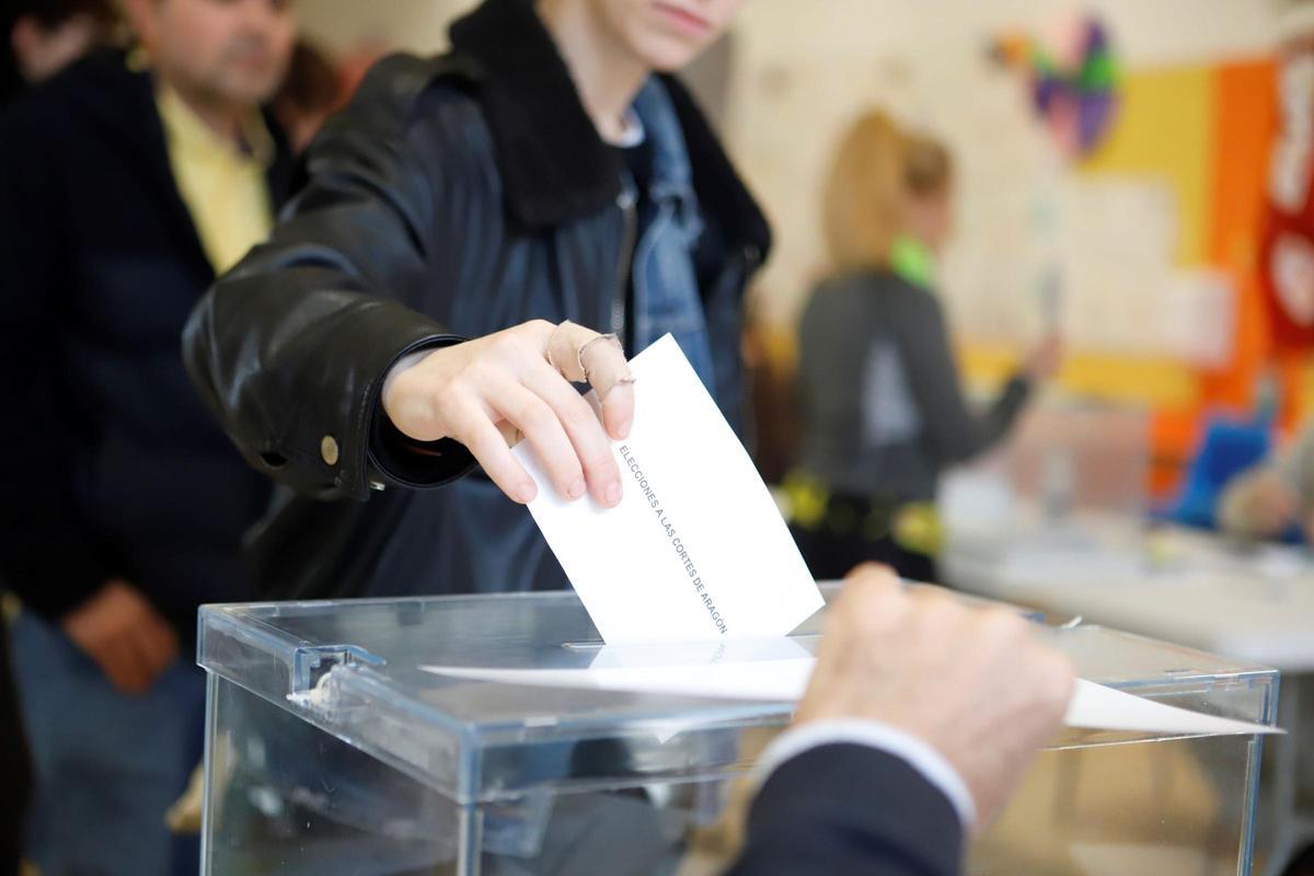 Una persona deposita su papeleta dentro de la urna.