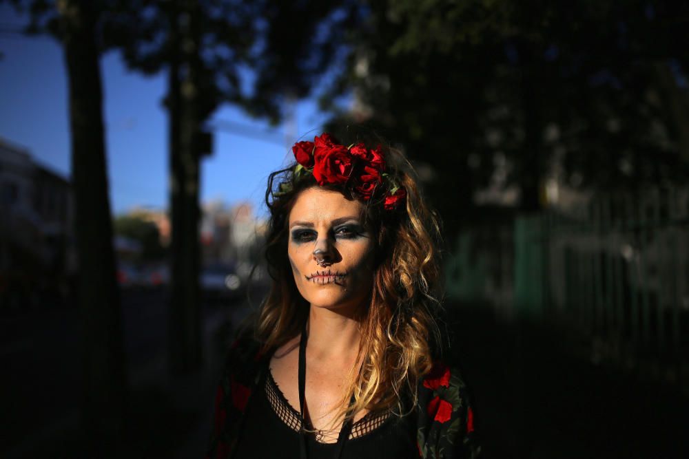 A woman wears makeup and a costume as she ...