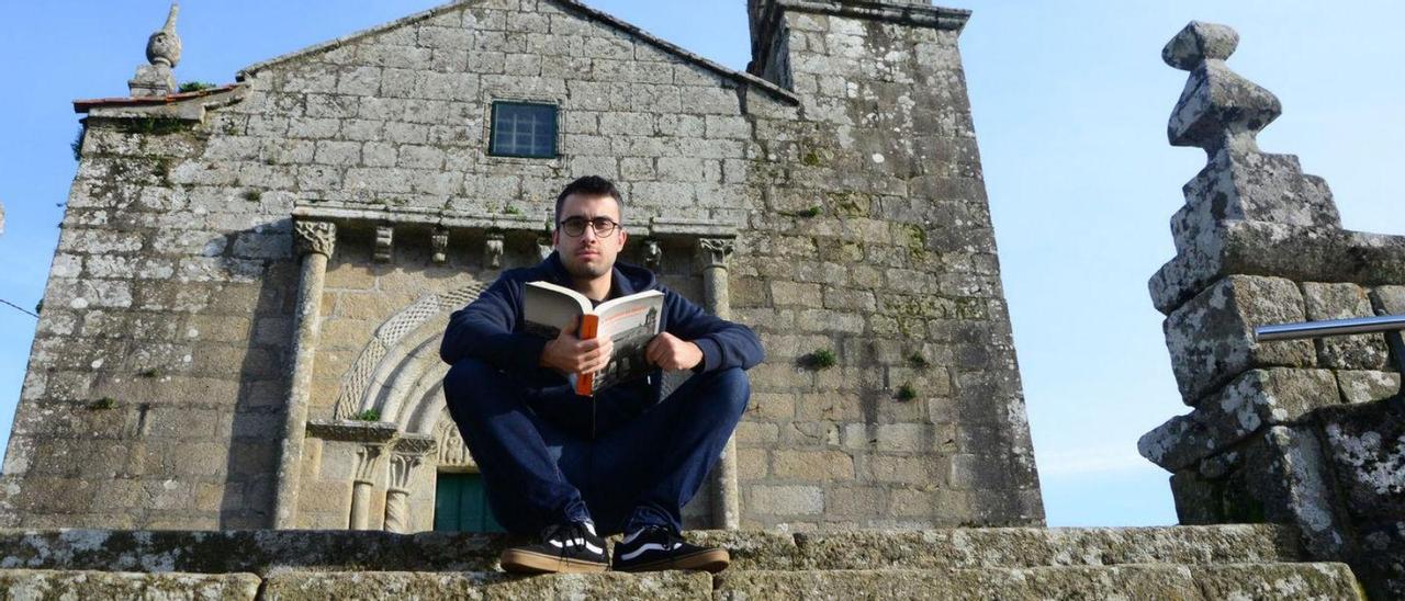 Mauro Pérez, ayer, ante el templo románico con el libro ‘A freguesía de Moaña’.
