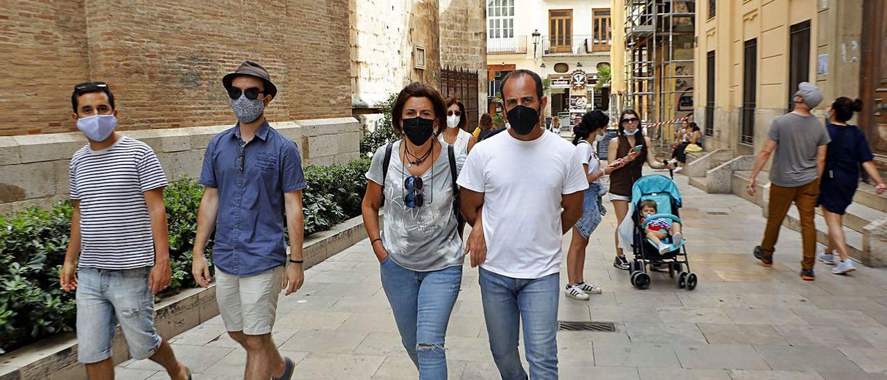 Un grupo de personas con la mascarilla puesta, ayer en el centro de València.  | M.ÁNGEL MONTESINOS