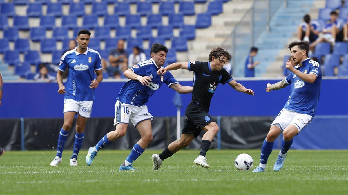 Lorenzo Amatucci conduce el balón ante tres jugadores del Real Oviedo.