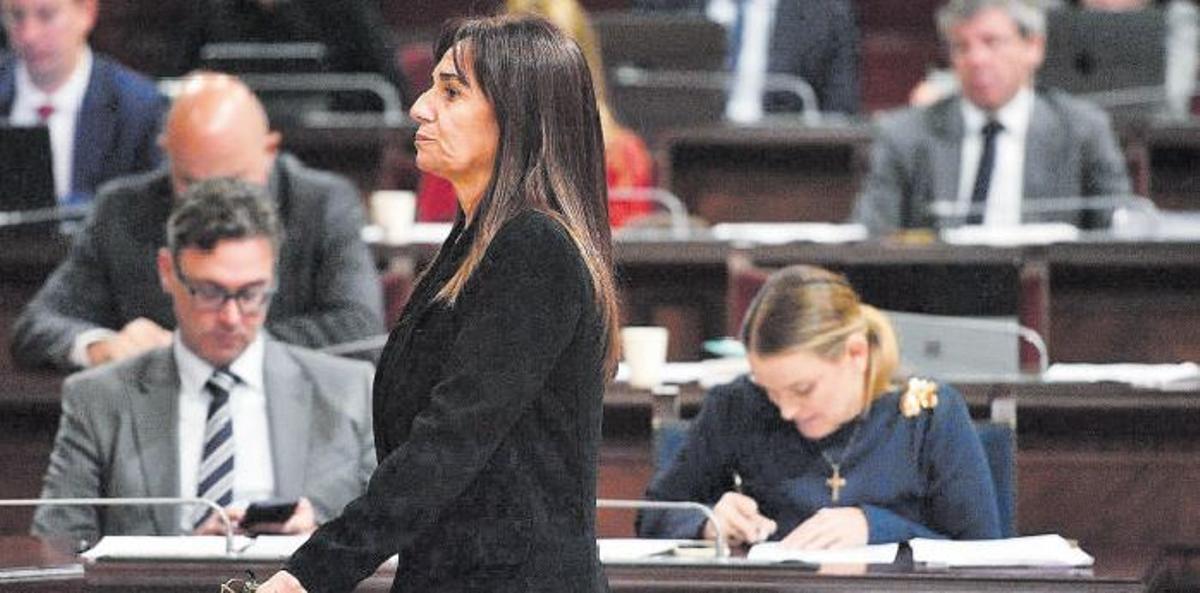 Manuela Cañadas pasa delante de Marga Prohens durante un pleno del Parlament