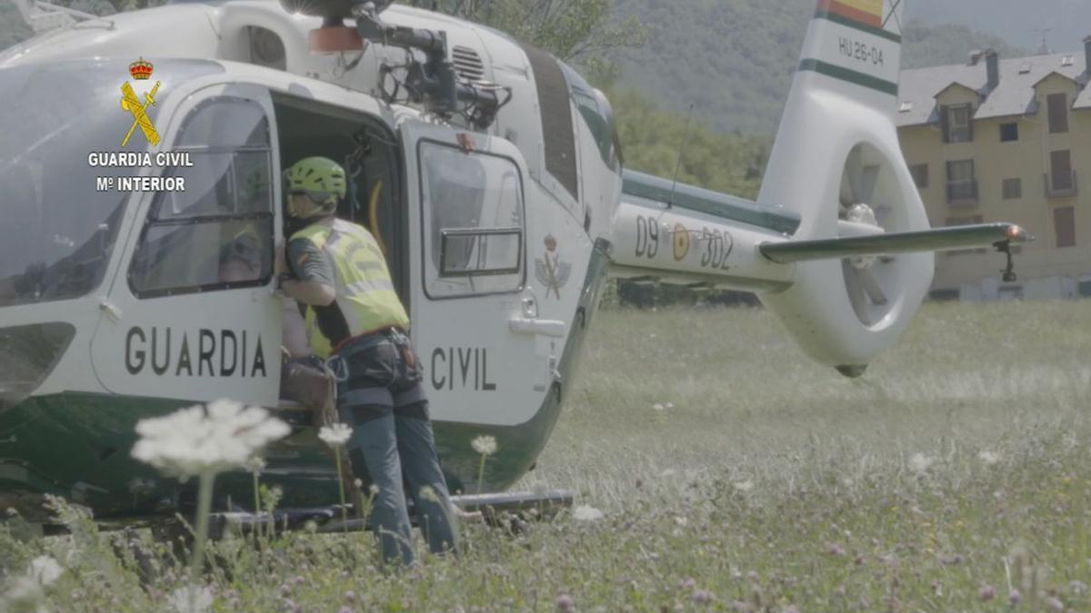 Un agente introduce en el helicóptero a uno de los heridos de la avioneta.
