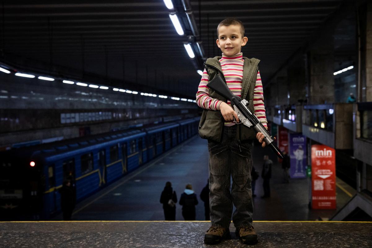 Tima, de 6 años, sostiene un rifle de juguete en una estación de metro que sirve como refugio de posibles ataques aéreos, mientras continúa el ataque de Rusia contra Ucrania, en Kiev, Ucrania.