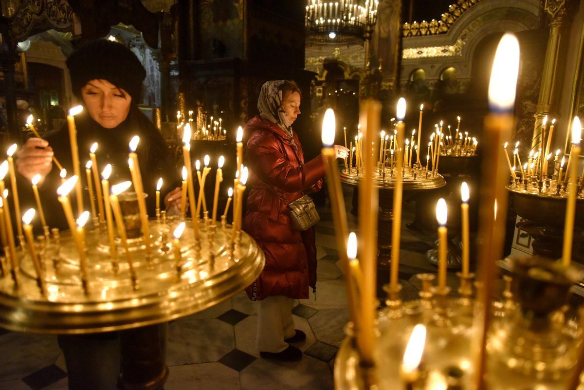  Los creyentes encienden velas durante un servicio de oración de Nochebuena en la Catedral de San Volodymyr en Kyiv.