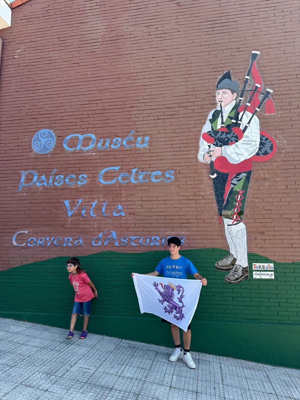 Un grupo se fotografía ante el gaitero de la fachada.