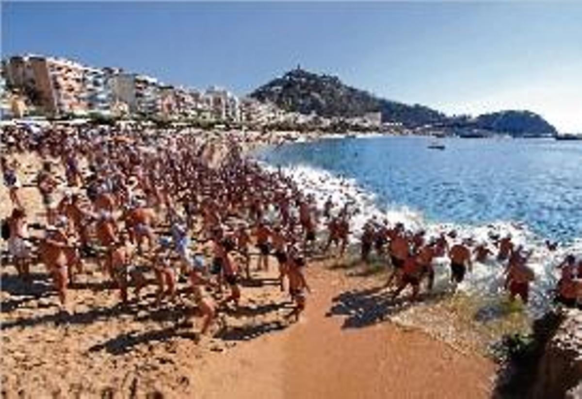 Els participants de la travessa, sortint des de la platja.
