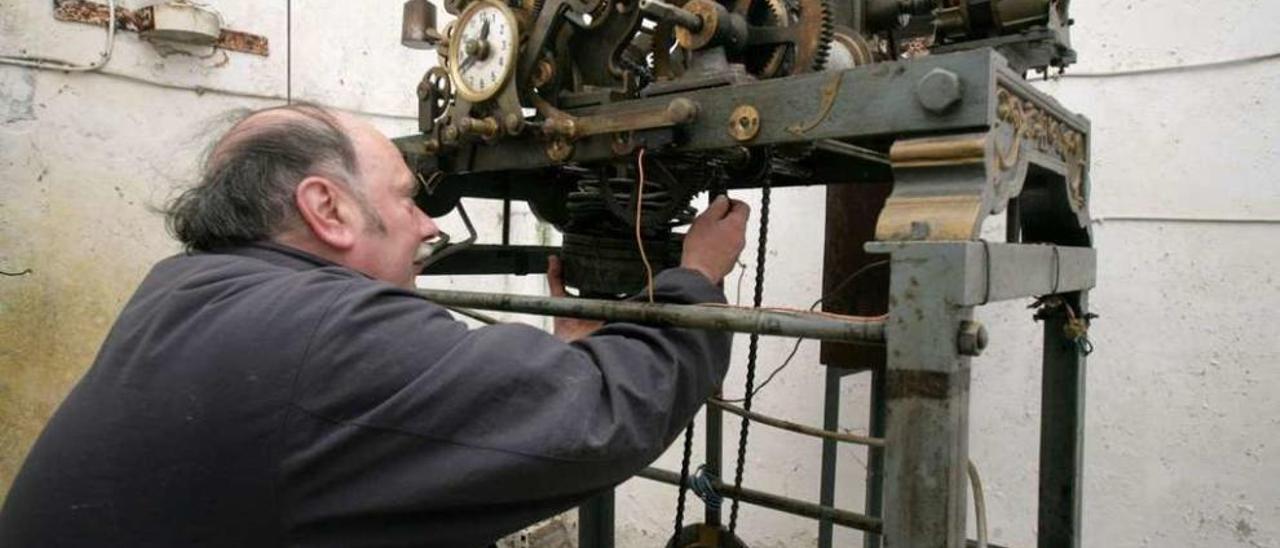 El relojero Manuel Puente, ayer, revisando la maquinaria de este reloj. // Bernabé/Víctor Espiño