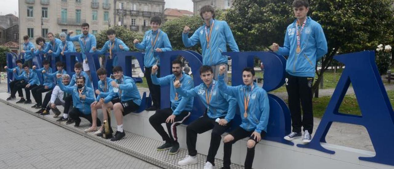 El equipo juvenil del Cisne tras su llegada, ayer, a Pontevedra, junto a su entrenador y al presidente del club. |  // RAFA VÁZQUEZ