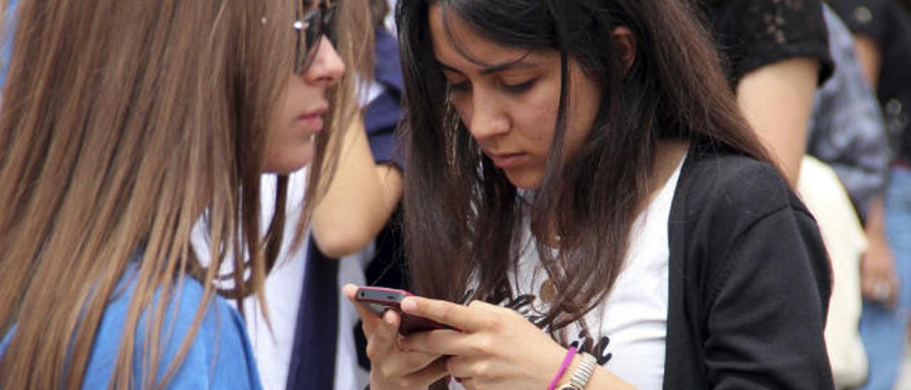 Una joven hace uso de su teléfono móvil.