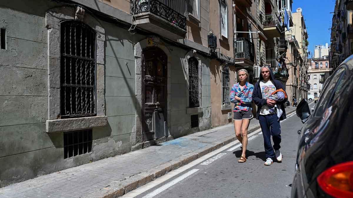 Dos turistas pasan por el lugar donde se produjo el tiroteo, la noche del viernes, en la Barceloneta.