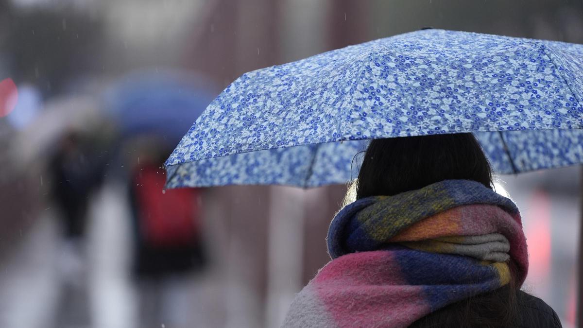 Una persona se protege de la lluvia con un paraguas