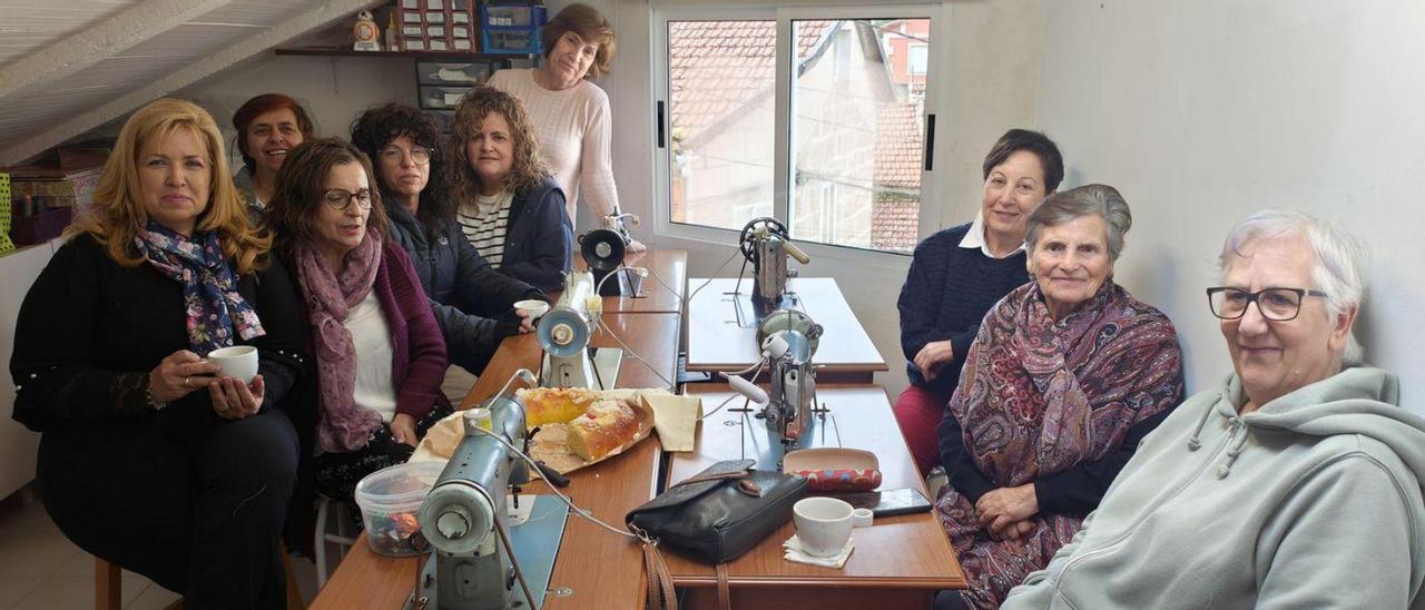 Mercedes Barreiro, al fondo, con las amigas a las que enseña, junto a sus máquinas históricas.