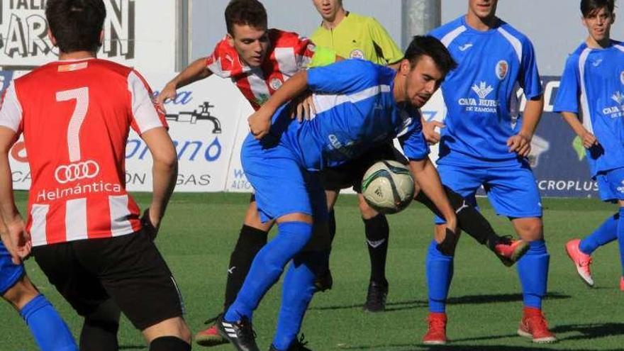 Un jugador de cada equipo pelea por el balón.