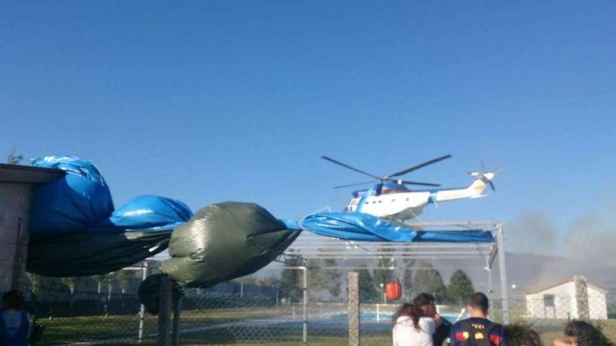 Un helicóptero de Medio Rural, cogiendo agua en la piscina de A Mezquita. // FdV