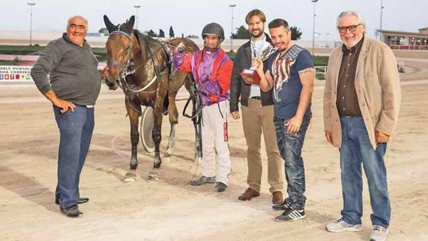 Mateu Calvo muerde el trofeo que ganó ayer Dream de Font conducido por Joan Toni Riera.