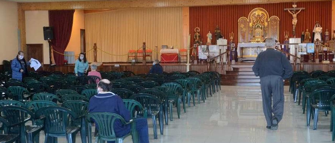 Fieles asisten a la misa celebrada en el salón parroquial de la iglesia de Caleiro. // Noé Parga