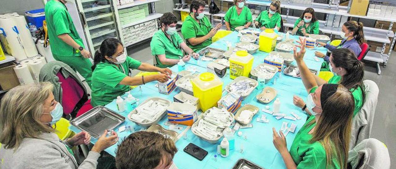 Profesionales preparan las vacunas en una jornada habitual en uno de los «vacunódromos» de la provincia. | ALEX DOMINGUEZ