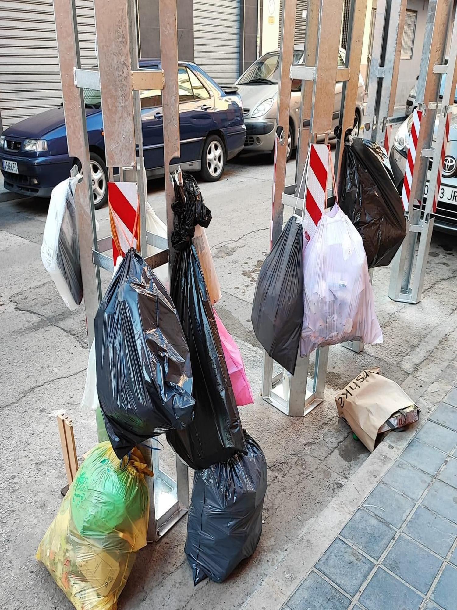 Bolsas de basura junto a cubos en Meliana.