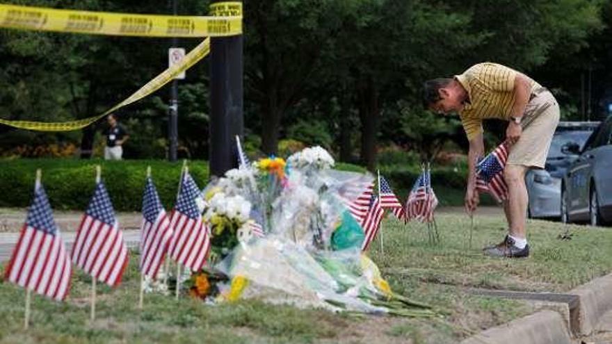 Un hombre clava una bandera en la zona de la masacre.  // Reuters