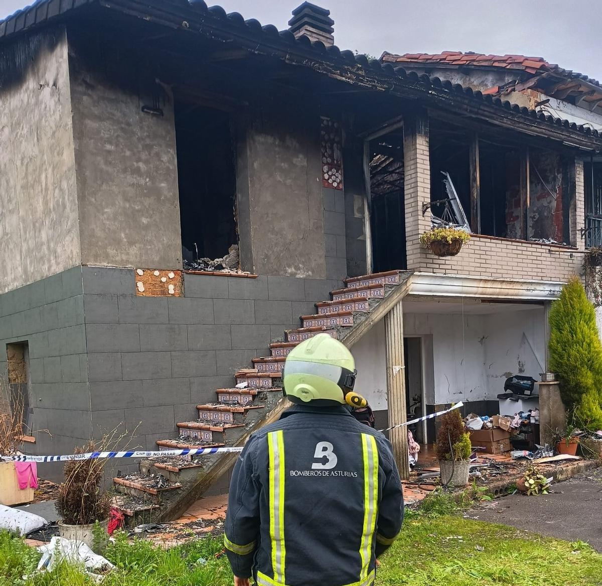 Un bombero ante la vivienda que quedó calcinada.