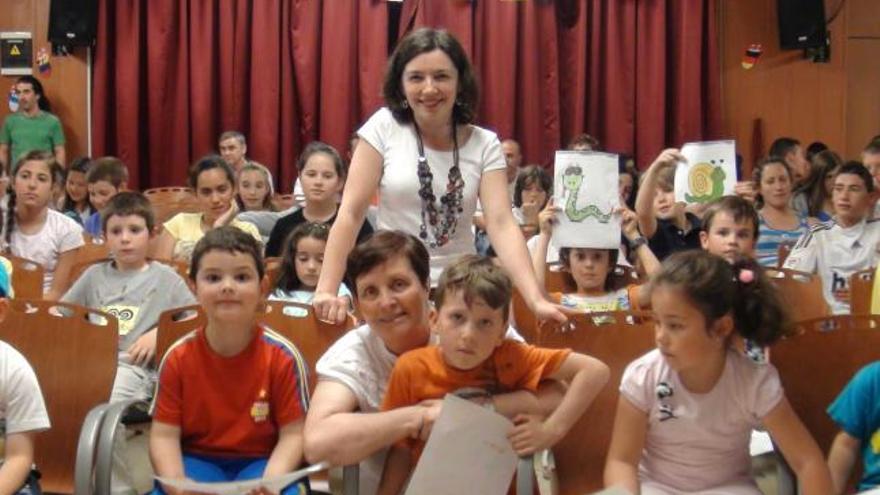 Marisa López, de pie, y Aurora García, en cuclillas, con los niños del colegio de ibias.