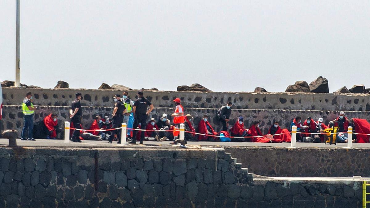 Cruz Roja y Policía Nacional, ayer, en el puerto de Arrecife con los migrantes llegados a La Graciosa. | | JAVIER FUERTES