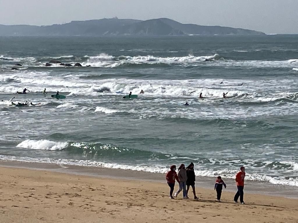 Muchos ciudadanos aprovechan el fin de semana y el buen tiempo para hacer surf y pasear por A Lanzada.