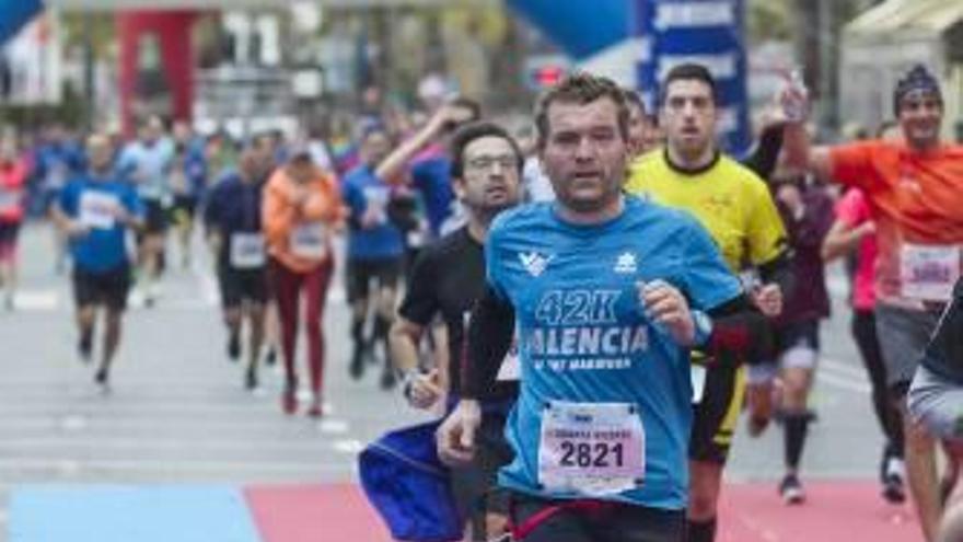 Un atleta corre con su mascota. Dos deportistas se besan tras terminar la Mitja Marató y un deportista nada más terminar la carrera.