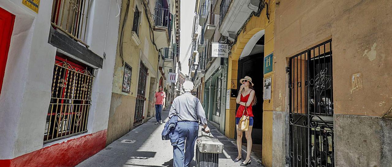 Un turista circula con una maleta de viajes por el centro de Palma.