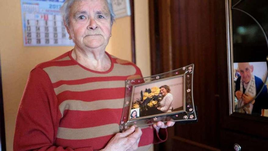 Mercedes Caíñas muestra la foto de su hija Ana Isabel, en su casa de Murias.