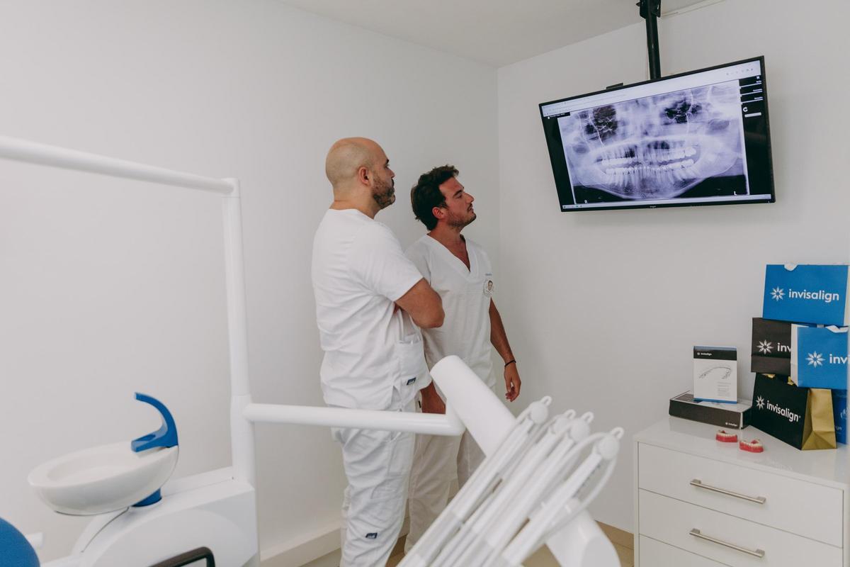 Dos profesionales estudian la radiografía de un paciente.