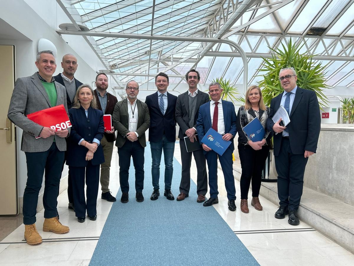 Varios diputados del Parlamento de Cantabria, en uno de los pasillos más afectados por las goteras, donde se ha colocado una alfombra antideslizante.